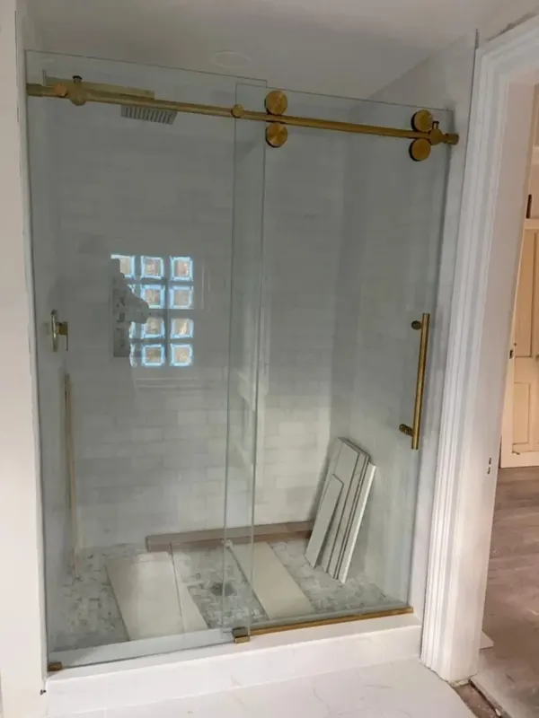 Glass shower enclosure with gold hardware